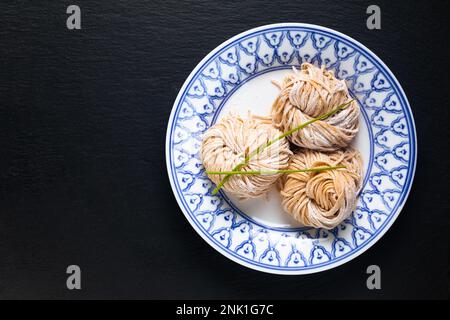 Cuisine asiatique concept frech maison bio chinois nouilles aux œufs alcalins sur fond noir avec espace de copie Banque D'Images