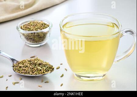 Eau de fenouil dans une tasse de verre avec graines de fenouil en arrière-plan Banque D'Images
