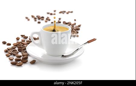 Un café éclabousse dans une tasse avec des grains dispersés isolés sur un blanc Banque D'Images