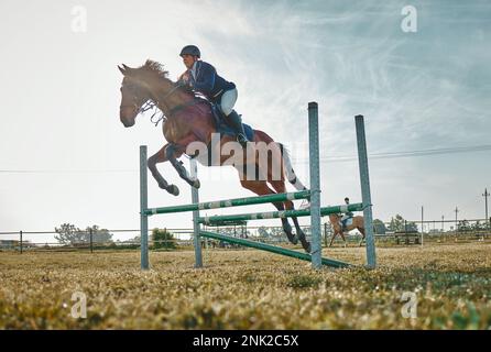 Entraînement, compétition et femme sur un cheval pour le sport, un événement ou un spectacle sur un terrain en Norvège. Saut, action et fille faisant un cours d'équitation Banque D'Images