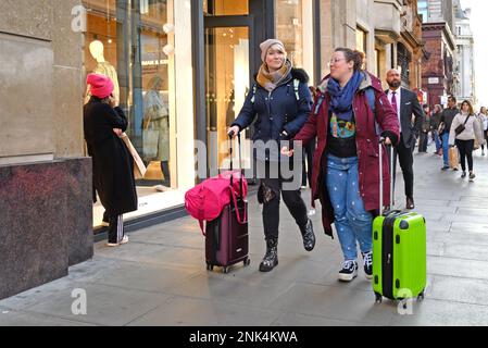 Londres, Angleterre, Royaume-Uni. Deux femmes en roue de bagages à Oxford Street Banque D'Images