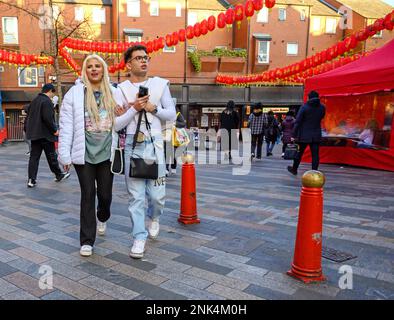 Londres, Angleterre, Royaume-Uni. Couple vêtu de blanc marchant dans Chinatown. Banque D'Images