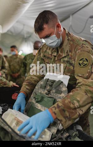 Le Sgt Trevor McCarson, spécialiste des soins aux animaux du détachement médical de 422nd (Services vétérinaires), prépare du matériel médical au cours d'une simulation d'entraînement de chien de travail militaire avec les États-Unis Personnel médical de la Marine pendant l'exercice de soutien au combat (CSTX) et Global Medic à fort McCoy, Wisconsin, le 11 août 2022. Une formation conjointe de la branche sur des simulations de ce genre est menée en raison de vétérinaires égoïsly étant dans le champ de bataille et cela prépare les hôpitaux à traiter les chiens de travail militaires. Banque D'Images