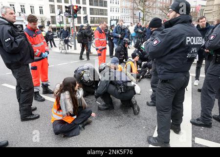 Hambourg, Allemagne. 23rd févr. 2023. Les policiers détachent les mains enregistrées des activistes du groupe environnemental 'dernière génération' de la chaussée. Les militants veulent utiliser cette action pour attirer l'attention sur le respect des objectifs climatiques. Crédit : Bodo Marks/Bodo Marks/dpa/Alay Live News Banque D'Images