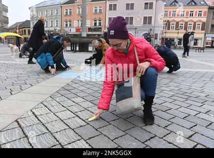 Prerov, République tchèque. 23rd févr. 2023. L'Assemblée pour commémorer les victimes de la guerre en Ukraine à la veille du premier anniversaire de l'invasion des troupes russes s'est tenue à 23 février 2023, sur la place T. G. Masaryk à Prerov (République tchèque). Les participants peignent un drapeau ukrainien symbolique et des images aux couleurs de ce drapeau sur le trottoir avec de la craie. Crédit : Ludek Perina/CTK photo/Alay Live News Banque D'Images