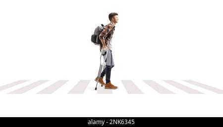 Un étudiant qui marche avec des béquilles sur un passage pour piétons isolé sur fond blanc Banque D'Images