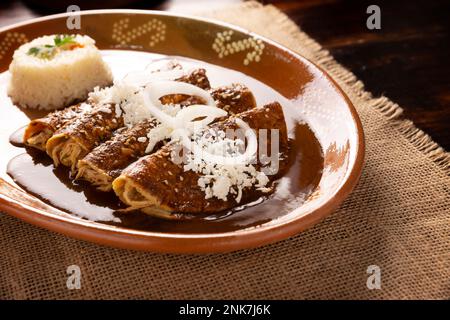 Enmoladas de poulet. Aussi connu sous le nom de mole poblano enchiladas, ils sont un plat mexicain typique qui est très populaire au Mexique et dans le reste du monde. Banque D'Images