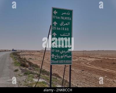Panneau routier dans le désert de Syrie, en direction de Bagdad en Irak Banque D'Images