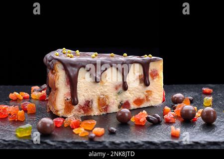 dessert au fromage cottage avec chocolat et fruits confits, sur fond noir Banque D'Images
