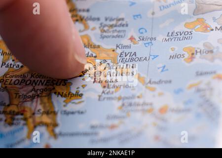 Gros plan du doigt pointant vers Athènes, Grèce sur une carte colorée, flou d'arrière-plan Banque D'Images