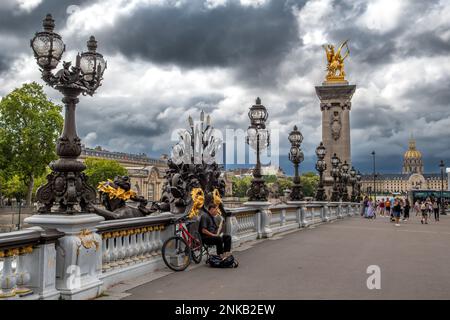 PARIS, FRANCE - août 15 2022 : Dôme de l'Eglise des Invalides et Pont Alexandre III avec musicien de rue à Paris, France Banque D'Images