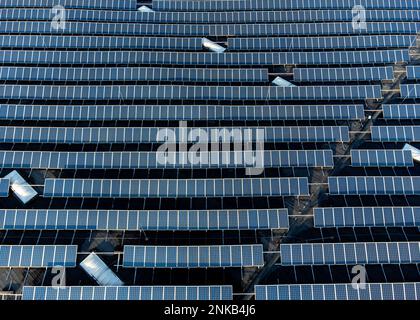 Grande ferme empilée de panneaux solaires sur un bâtiment d'entrepôt de distribution, vue aérienne en haut vers le bas Banque D'Images