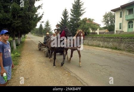 Comté de Suceava, Roumanie, environ 2000. Les gens qui voyagent sur une route rurale avec un chariot tiré par des chevaux. Banque D'Images