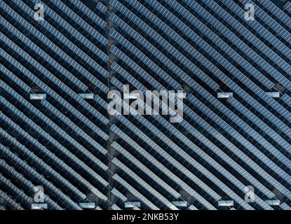 Grande ferme empilée de panneaux solaires sur un bâtiment d'entrepôt de distribution, vue aérienne en haut vers le bas Banque D'Images