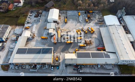 Construction et usine de béton lot, panneaux solaires sur le toit et camions de ciment jaune sur le site Banque D'Images