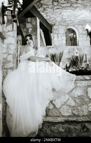 Moody belle mariée assise parmi les murs de pierre, comme princesse dans le château en attente du prix Banque D'Images