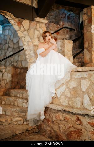 Moody belle mariée assise parmi les murs de pierre, comme princesse dans le château en attente du prix Banque D'Images