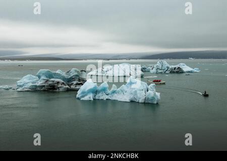 Icebergs et bateau d'excursion dans le lagon du glacier de Joekulsarlon, sur la côte sud de l'Islande Banque D'Images