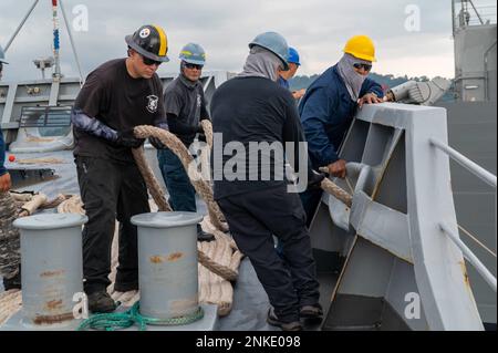 SUBIC BAY (Philippines) (13 août 2022) - les marins de la fonction publique du Commandement du Sealift militaire, affectés à l'appel d'offres sous-marin de classe Emory S. Land USS Frank Cable (AS 40), ont laissé une ligne d'amarrage à l'amarrage à Subic Bay (Philippines), le 13 août 2022. Frank Cable est actuellement en patrouille pour effectuer l'entretien et la logistique expéditionnaires dans la zone d'opérations de la flotte 7th afin de soutenir un Indo-Pacific libre et ouvert. Banque D'Images