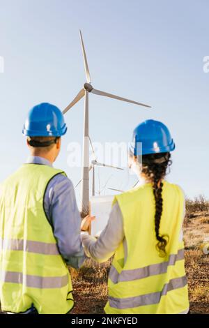 Les ingénieurs discutent au-dessus des éoliennes par temps ensoleillé Banque D'Images