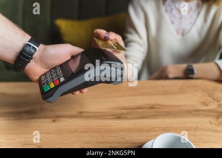 Femme effectuant le paiement par carte de crédit au café Banque D'Images