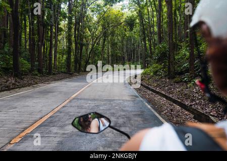 Reflet du couple dans le rétroviseur latéral sur route Banque D'Images