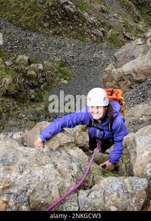 Femme heureuse portant un casque d'escalade, Lake District, Angleterre Banque D'Images