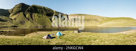 Tentes au bord du lac en face des montagnes, Brecon Beacons, pays de Galles Banque D'Images