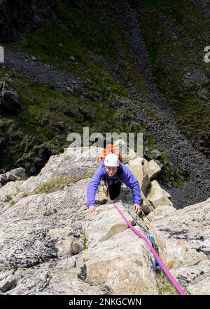 Femme grimpant sur le pilier de montagne, Western Fells, Lake District, Angleterre Banque D'Images