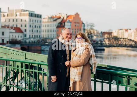 Couple de personnes âgées heureux debout près de la main courante Banque D'Images