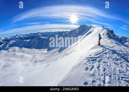 Autriche, Tyrol, soleil qui brille sur une femelle skieuse en admirant le paysage enneigé dans les Alpes de Tux Banque D'Images