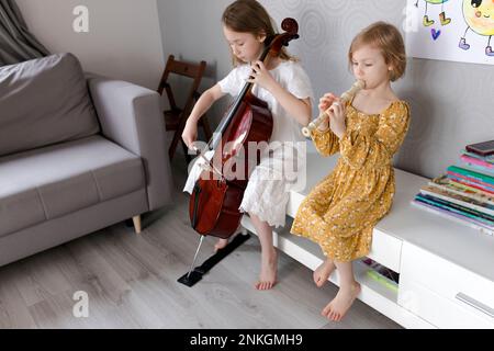 Sœurs jouant des instruments de musique à la maison Banque D'Images