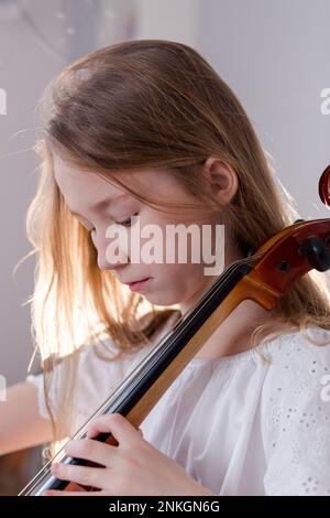 Fille pratiquant le violoncelle à la maison Banque D'Images