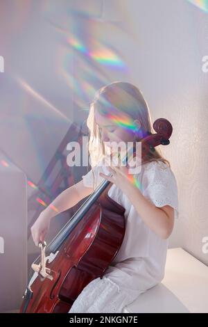 Fille jouant du violoncelle à la maison Banque D'Images