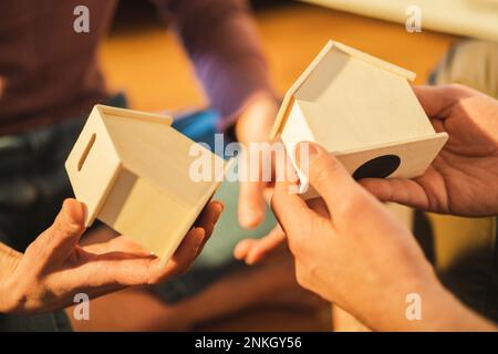 Mains de couple tenant des modèles de maison Banque D'Images