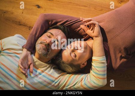 Homme et femme allongé sur le sol à la maison Banque D'Images
