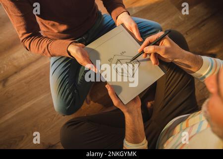 Homme mûr expliquant le projet de maison à la femme à la maison Banque D'Images