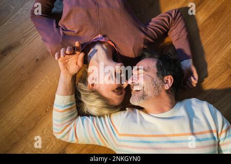 Heureux couple marié avec les yeux fermés de repos sur le sol à la maison Banque D'Images