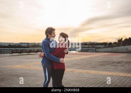 Couple d'âge mûr aimant s'embrassant au coucher du soleil Banque D'Images