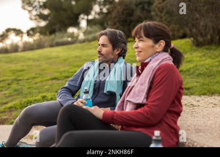 Homme mûr et femme attentionnés assis dans le parc Banque D'Images