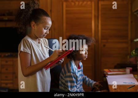 Frère et soeur à faire des devoirs à la maison Banque D'Images