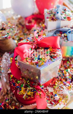 Boîte cadeau avec confettis sur le bureau Banque D'Images