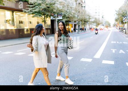 Amis marchant ensemble sur street Banque D'Images