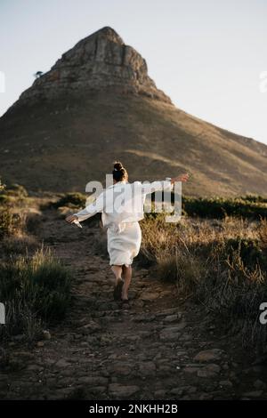 Femme en train de courir vers la montagne de Lion's Head au coucher du soleil Banque D'Images