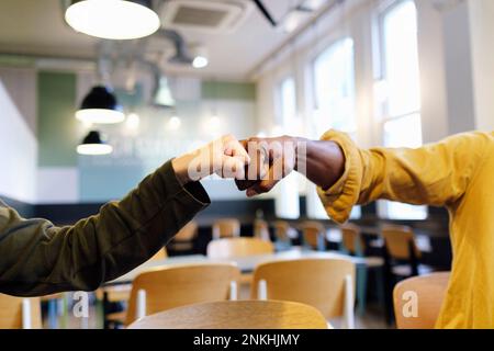 Les mains de collègues de travail qui donnent le coup de poing au bureau Banque D'Images