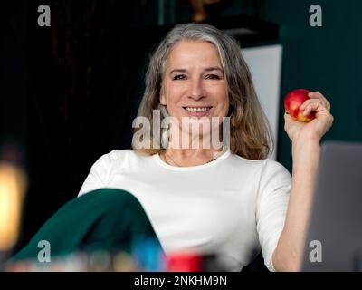 Bonne femme d'affaires tenant la pomme au bureau Banque D'Images