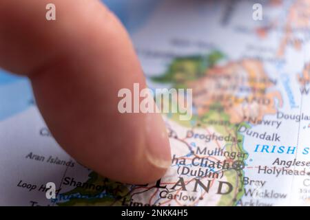 Gros plan du doigt pointant vers Dublin, Irlande sur une carte détaillée et colorée avec mise au point sélective, faible profondeur de champ, flou d'arrière-plan Banque D'Images