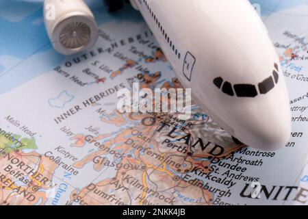 Gros plan d'un avion de passagers miniature sur une carte colorée montrant Edimbourg, Dundee Scotland grâce à une mise au point sélective et un flou d'arrière-plan Banque D'Images