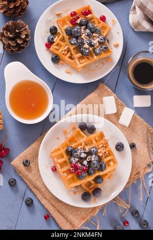 Gaufres avec cassis et bleuets sur un plat blanc. Banque D'Images