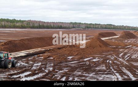 Vue sur la nature d'une tourbière avec un chantier de creusage de tourbe et un tracteur Banque D'Images